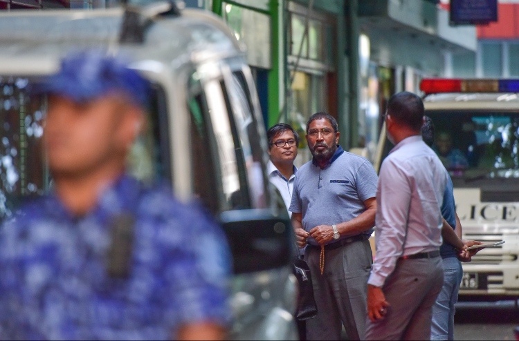 Gasim, looking on as police raid continues