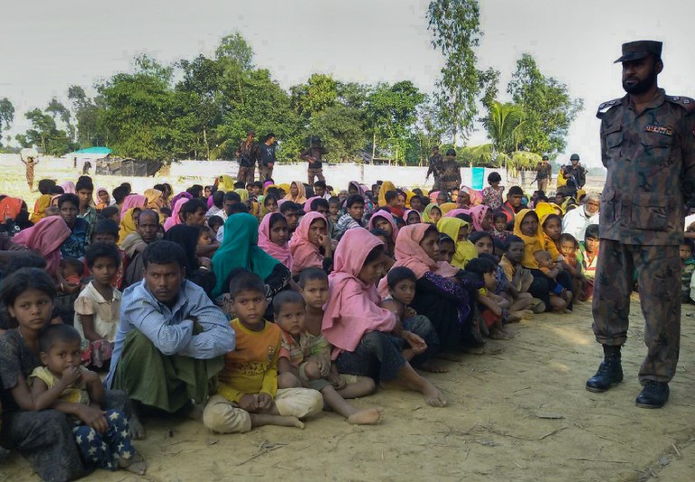 Rohingya Muslims from Myanmar, who tried to cross the Naf river into Bangladesh to escape sectarian violence, are kept under watch by Bangladeshi security officials in Teknaf on December 25, 2016. Border Guard Bangladesh (BGB) personnel have intercepted 34 boats carrying some 340 Rohingyas at border points near Cox's Bazar. / AFP PHOTO / STR