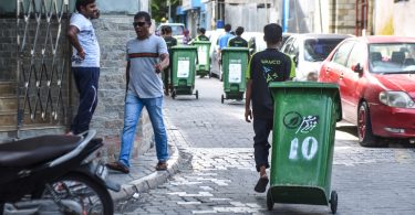 A waste collector from Waste Management Corporation (WAMCO) taking trash out of a house in the capital Male. PHOTO / MIHAARU