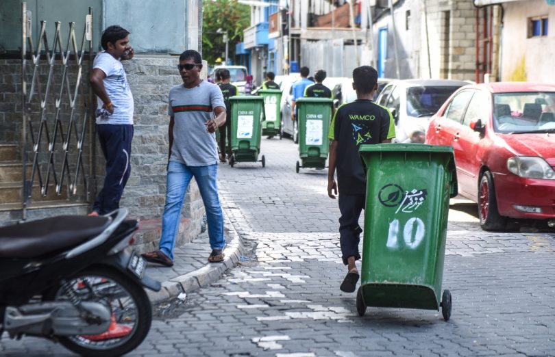A waste collector from Waste Management Corporation (WAMCO) taking trash out of a house in the capital Male. PHOTO / MIHAARU