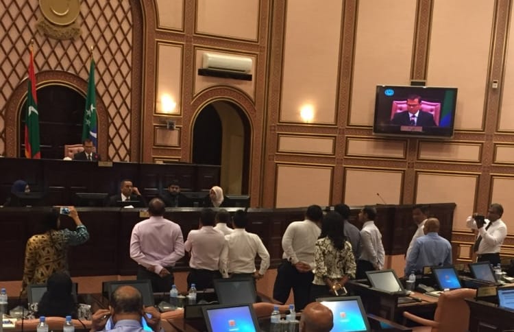 Speaker Abdulla Maseeh addresses the first sitting of 2017's third term of the parliament from his elevated seat behind a wooden "wall", while opposition lawmakers protest and call on him to step down. PHOTO/MAJLIS
