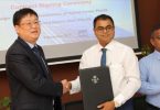 Sinomach International Sungrow company's vice president Ziyao Zian Don (L) and environment minister Thoriq Ibrahim sign contract awarding the installation of hybrid power plants in Shaviyani and Noonu atolls to Sinomach.