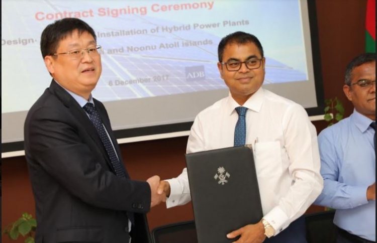 Sinomach International Sungrow company's vice president Ziyao Zian Don (L) and environment minister Thoriq Ibrahim sign contract awarding the installation of hybrid power plants in Shaviyani and Noonu atolls to Sinomach.