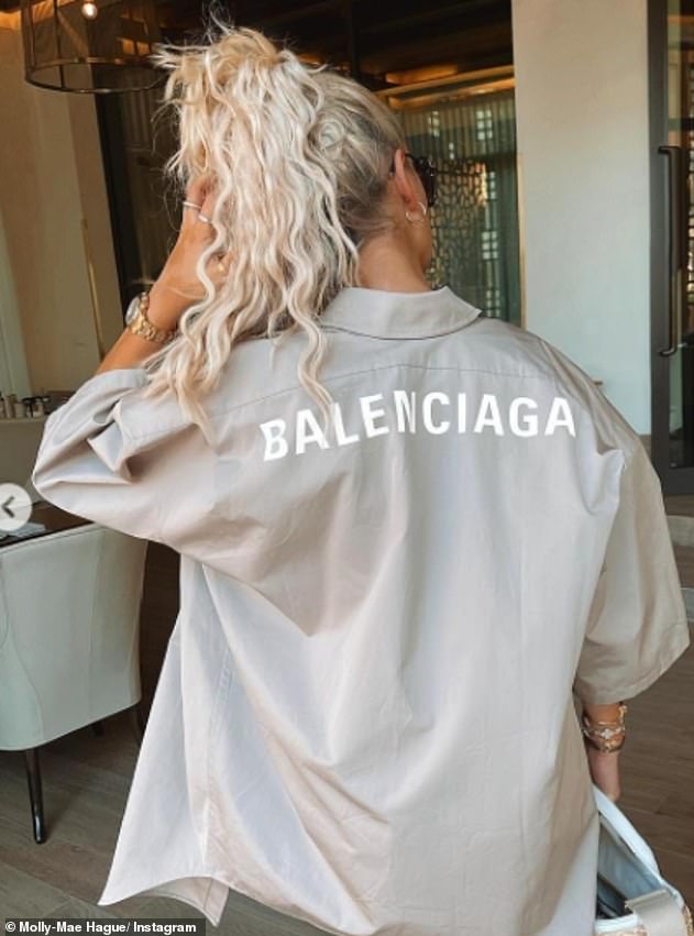 Stylish: In a nod to her love of all things designer, she turned her back to show her Balenciaga shirt and also clutched a Prada handbag