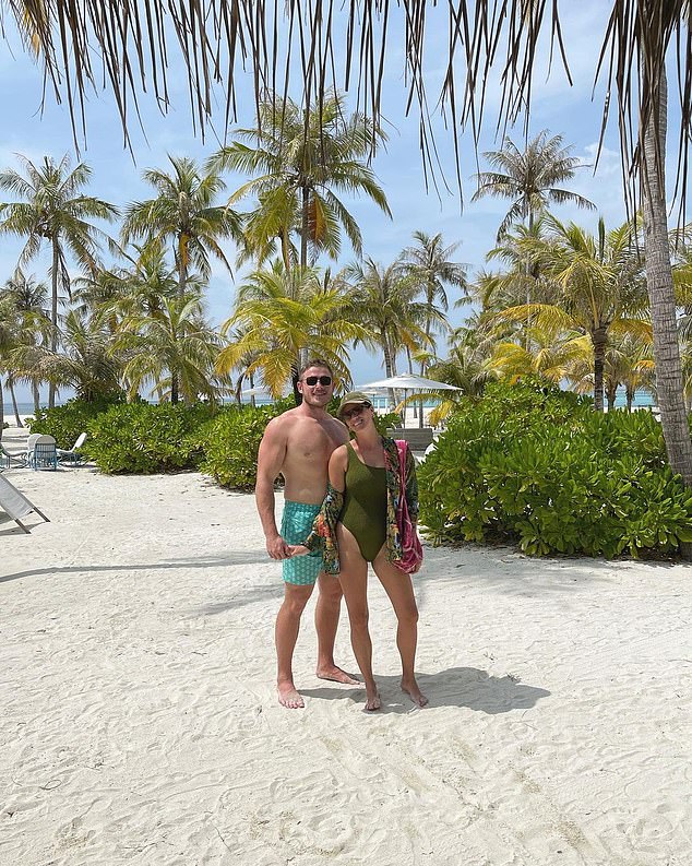 Dream holiday: In another photo, George and Joanna stood on the pristine white sand beach in front of a series of palm trees