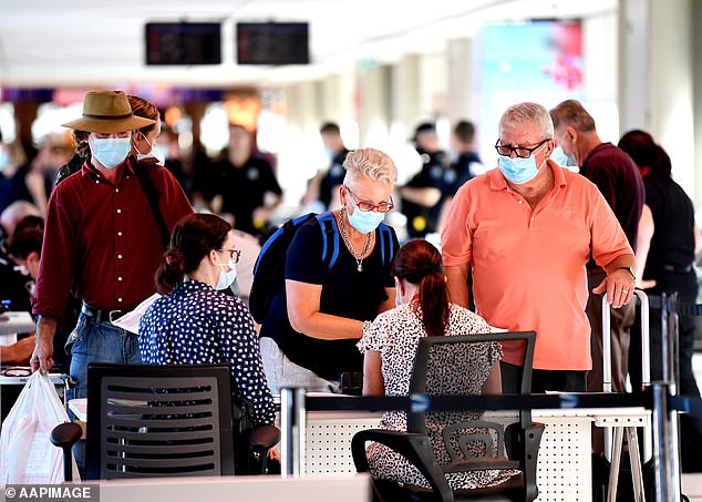 Incoming passengers are screened by police as they arrive at the domestic terminal in Brisbane airport on Sunday